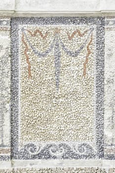 Old stone mosaic, detail of a wall decorated with colored stones, textured background
