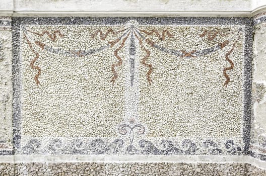 Old stone mosaic, detail of a wall decorated with colored stones, textured background
