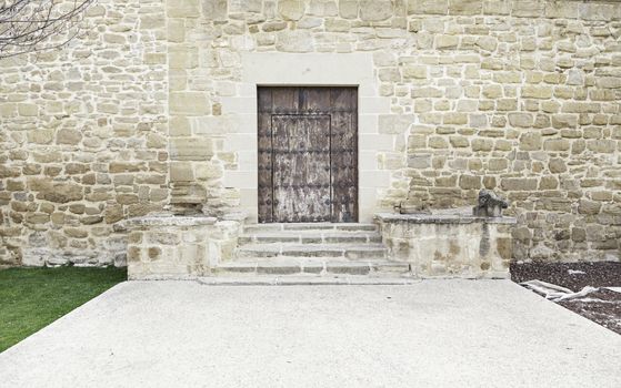 Ancient medieval wooden door, detail of a stone wall with a locked door, protection