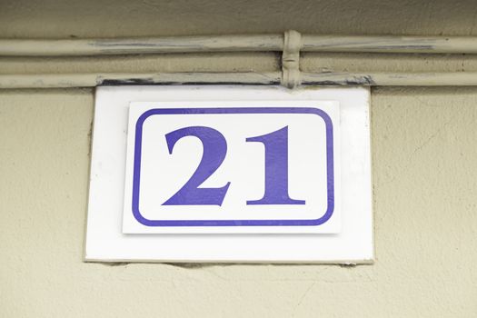 Number twenty-one on a wall, detail of a number of information in a house, odd number, figure number