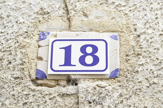 Number eighteen on a wall, detail of a number of information on a wall, even number