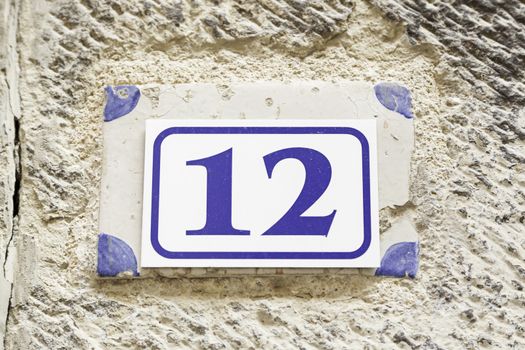 Number twelve on a wall, detail of a number of information on a wall of a house, even number