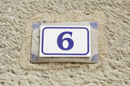 Number six on a wall, detail of a number of information on a wall of a house, even number