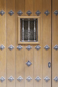 Old wooden door with window detail of a decorated wooden door, protection and decoration