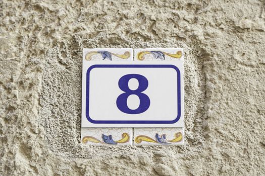 Number eight on a wall, detail of a number of information on a wall of a house, even number