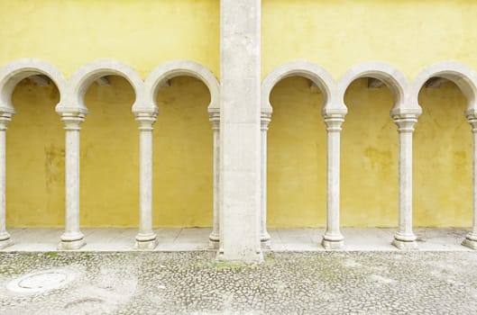 Ancient yellow arches in the Pena Palace, detail of ancient architecture, heritage of humanity, tourism