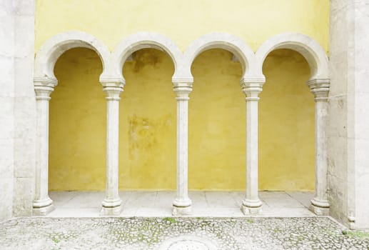 Ancient yellow arches in the Pena Palace, detail of ancient architecture, heritage of humanity, tourism