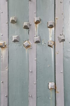 Old wooden door with metal nails, detail of a wooden door shabby textured background