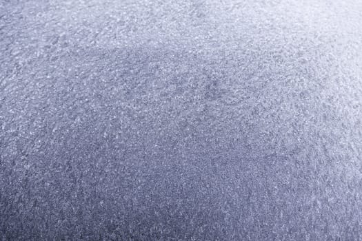 Blue ice on a wall, detail of a frozen wall, cold winter in the city