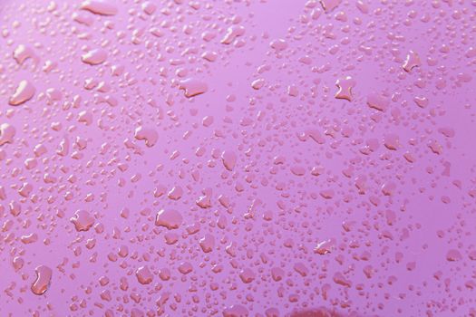 Raindrops on red wall, detail of a red wall wet with water, textured background
