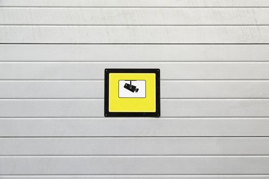 Signal surveillance camera, detail of a wall with a plate of surveillance information in the city