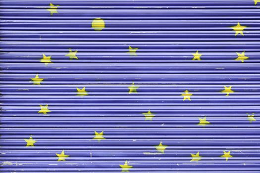 Blue painted metal gate, a gate detail with yellow stars painted decoration in the city