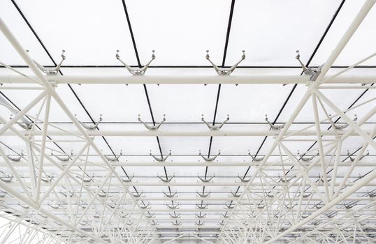 Glass roof with white beams, detail of a roof with sky views, safety and security