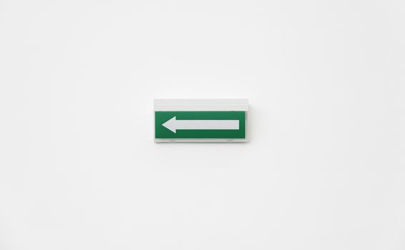 Green Arrow departure, detail of an arrow on a white wall, and safety information