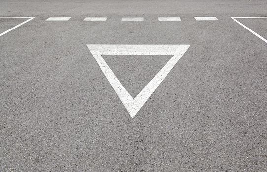 Give way sign on asphalt, detail of a traffic signal at the ciduad, information and road safety