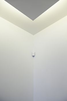 White wall with motion detector, detail of a wall with a security system