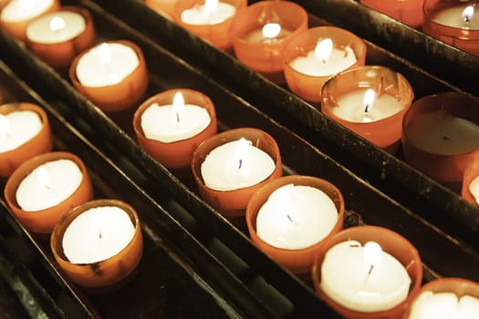Candles lighted wax candles detail inside a church, lighting and faith
