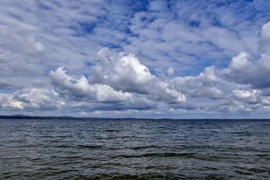 blue sky with powerful cumulonimbus clouds over the lake