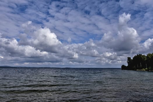 blue sky with powerful cumulonimbus clouds over the lake