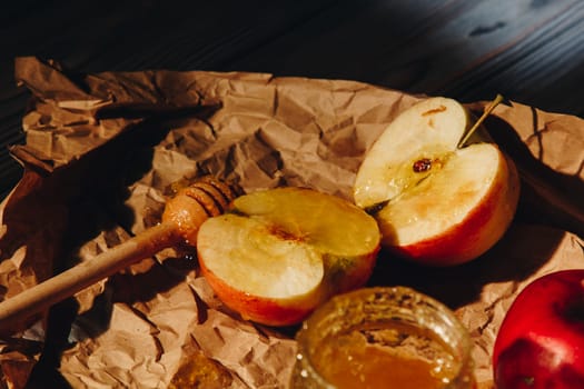 Honey with wooden honey dipper and fruits on wooden table close up