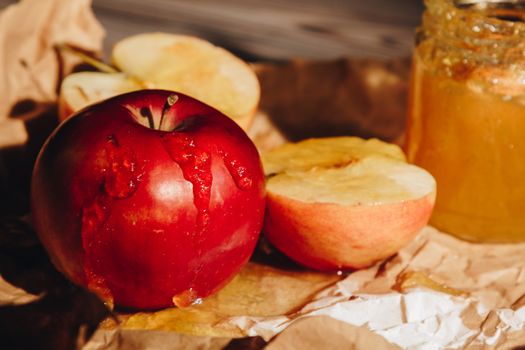 Honey with wooden honey dipper and fruits on wooden table close up