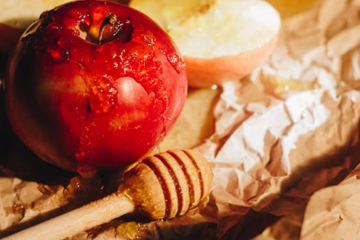 Honey with wooden honey dipper and fruits on wooden table close up