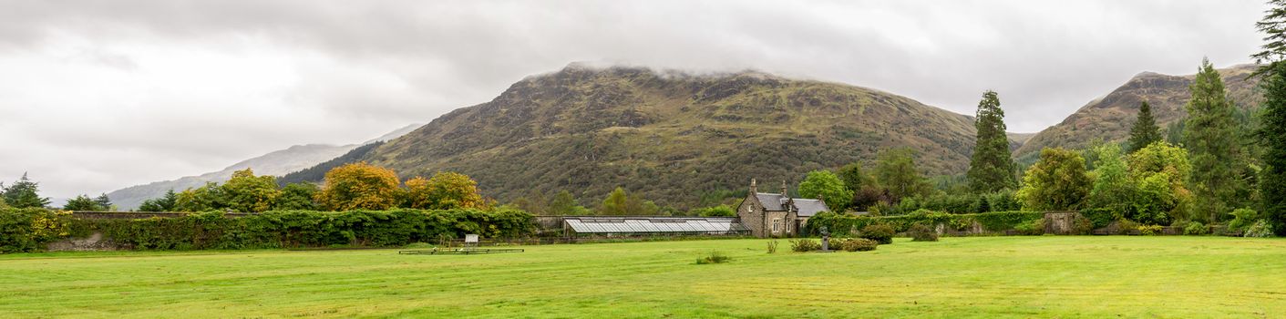 Panorama of the lawn in front of a glasshouse with plants in Benmore Botanic Garden, Loch Lomond and the Trossachs National Park, Scotland