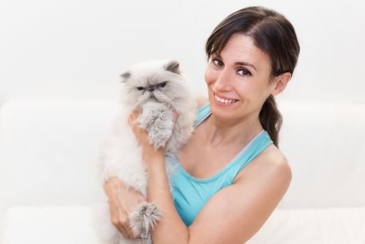 Young woman holding a persian cat