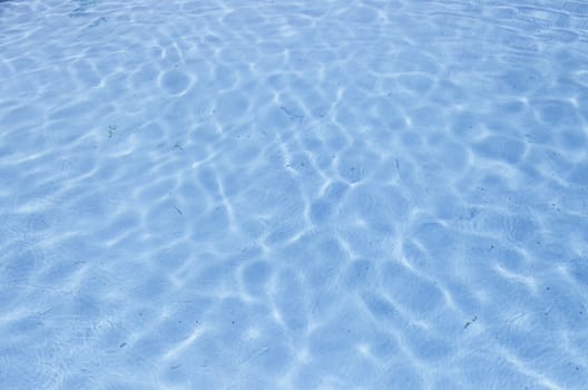 Swimming pool blue water detail in a summer swimming pool in town, hot and fun