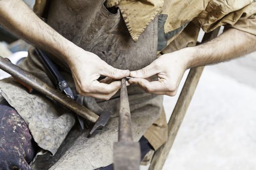 Worker metal craftsman, an artisan detail, tradition and old work