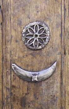 Old metal peephole, detail of an old wooden door with metal decoration, art and antiquity