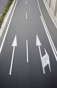 Arrows on the asphalt, detail of a road in the city, asphalt textured background