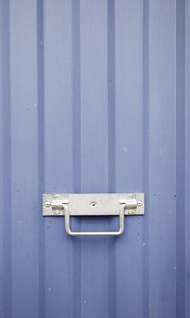 Blue metal door, detail of a wall decorated with metal handle, textured background