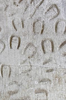 Traces of horseshoes on a concrete floor, detail of marks on the asphalt, animal tracks