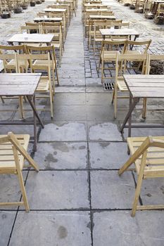 Wooden tables and chairs in the street, detail of a classic terrace in Spain, the relaxation and outdoor fun