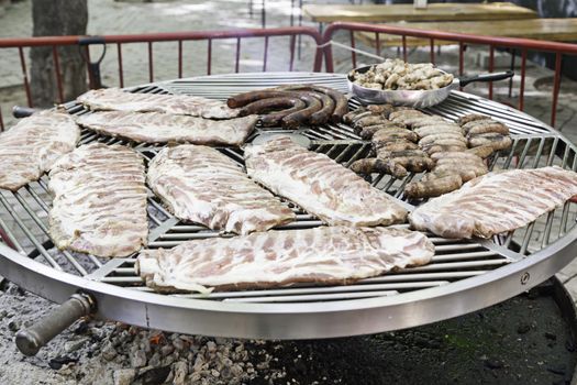 Roast ribs on a grill, detail of roast pork with coal