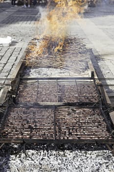 Roasted meat on a grill with fire, detail of a charcoal grilled beef, healthy food, traditional