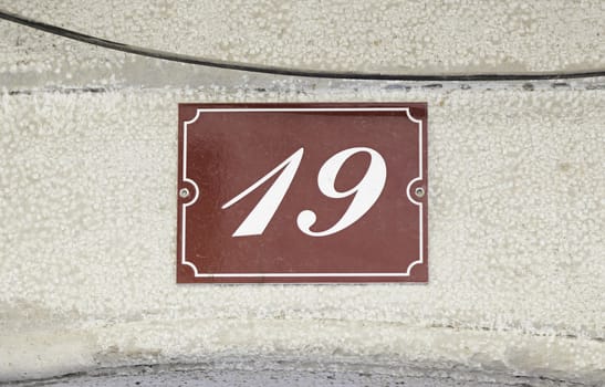 Metal plate with the number nineteen, detail of a data plate with a number