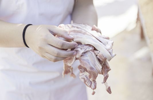 Raw bacon meat, detail of a woman fucking frying bacon slices, street food