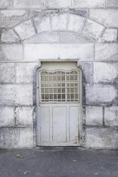 Old metal door in a stone wall, detail of a door in a historic building