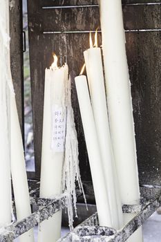 Japanese Candlesticks on, detail of a lit religious candles, belief and faith