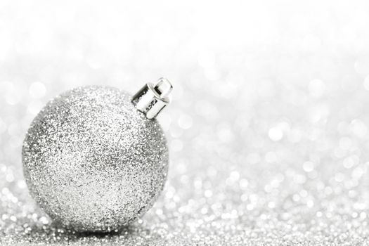 Christmas decorative ball on light silver bokeh background