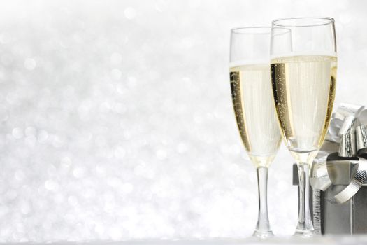 Champagne and present on silver bokeh background