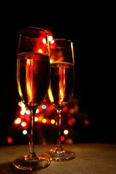 Two champagne glasses on color bokeh background