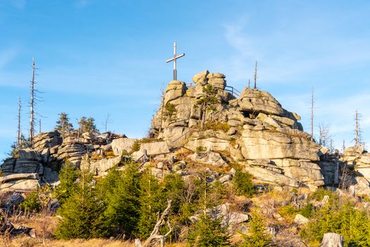 Granite rock formation with wooden cross on the top of Hochstein near Dreisesselberg, Tristolicnik. Border between Bayerische Wald in Germany and Sumava National Park in Czech Republic.