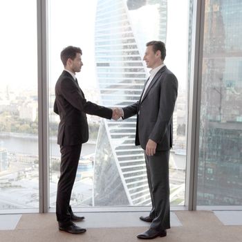 Business people shaking hands, finishing up a meeting in office
