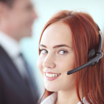 Portrait of a smiling creative businesswoman with earpiece in office