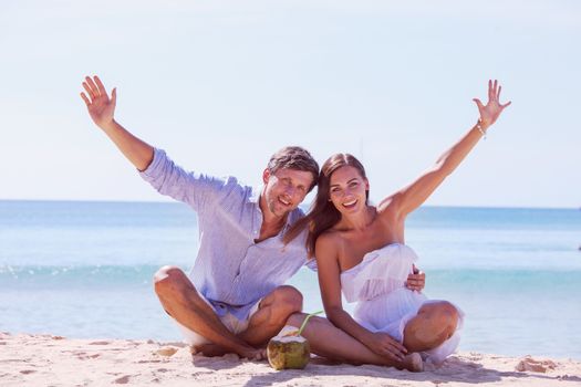 Young couple enjoying their time drinking a coconut cocktail on beach