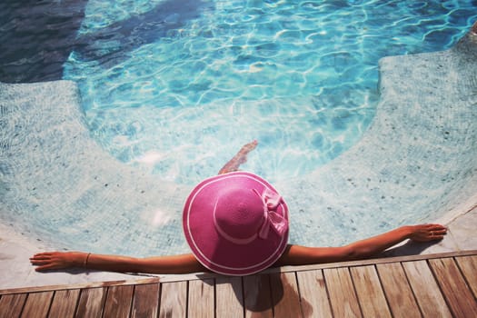 Beautiful woman relaxing at swimming pool at tourist resort