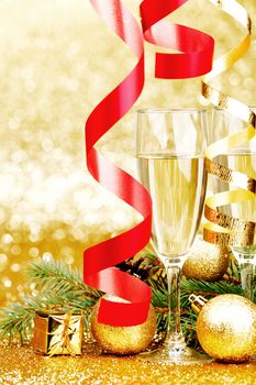 Champagne, fir tree, christmas decor and gifts on golden background